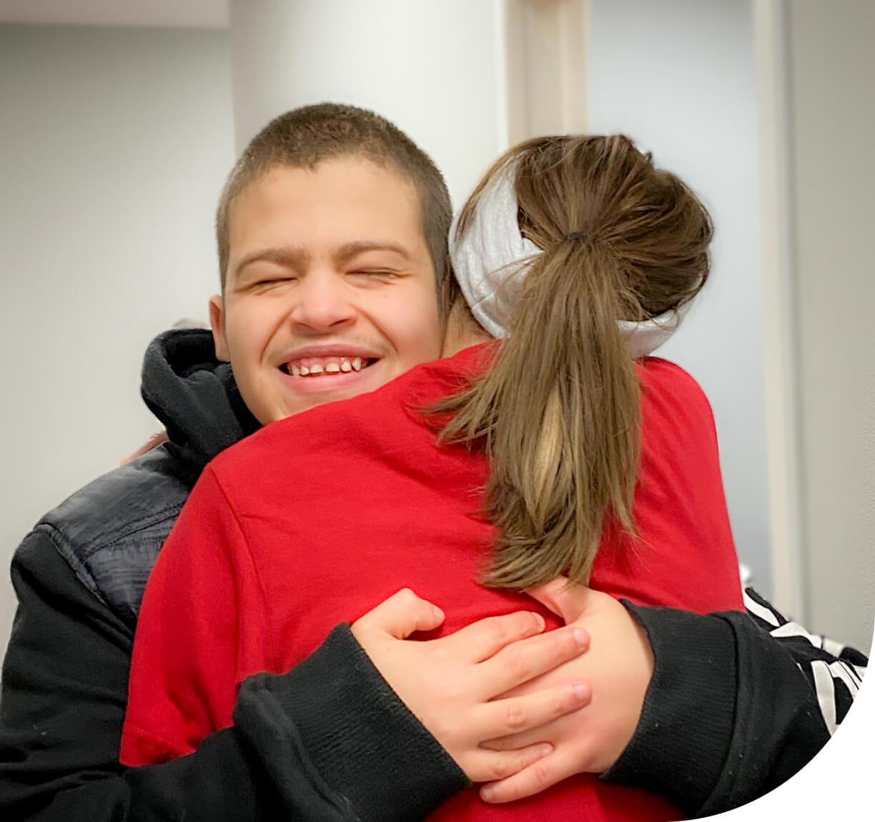 Two people hugging and smiling.