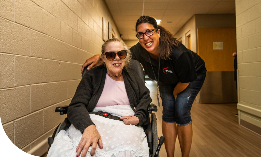 A woman taking a picture with an older lady in a wheelchair