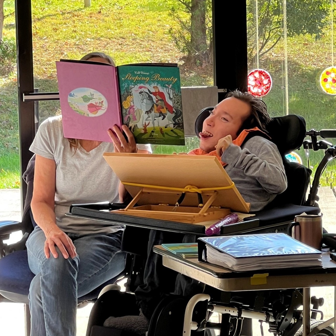 Caregiver reading a book to an adult client