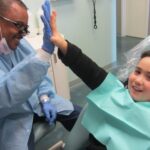 Child and dentist high fiving