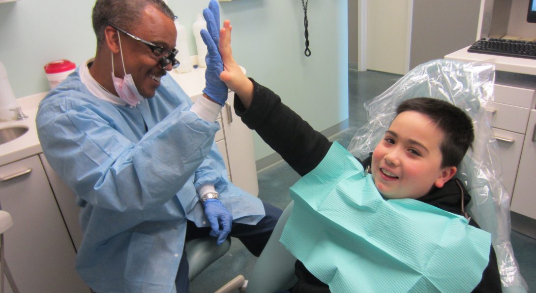 Child and dentist high fiving