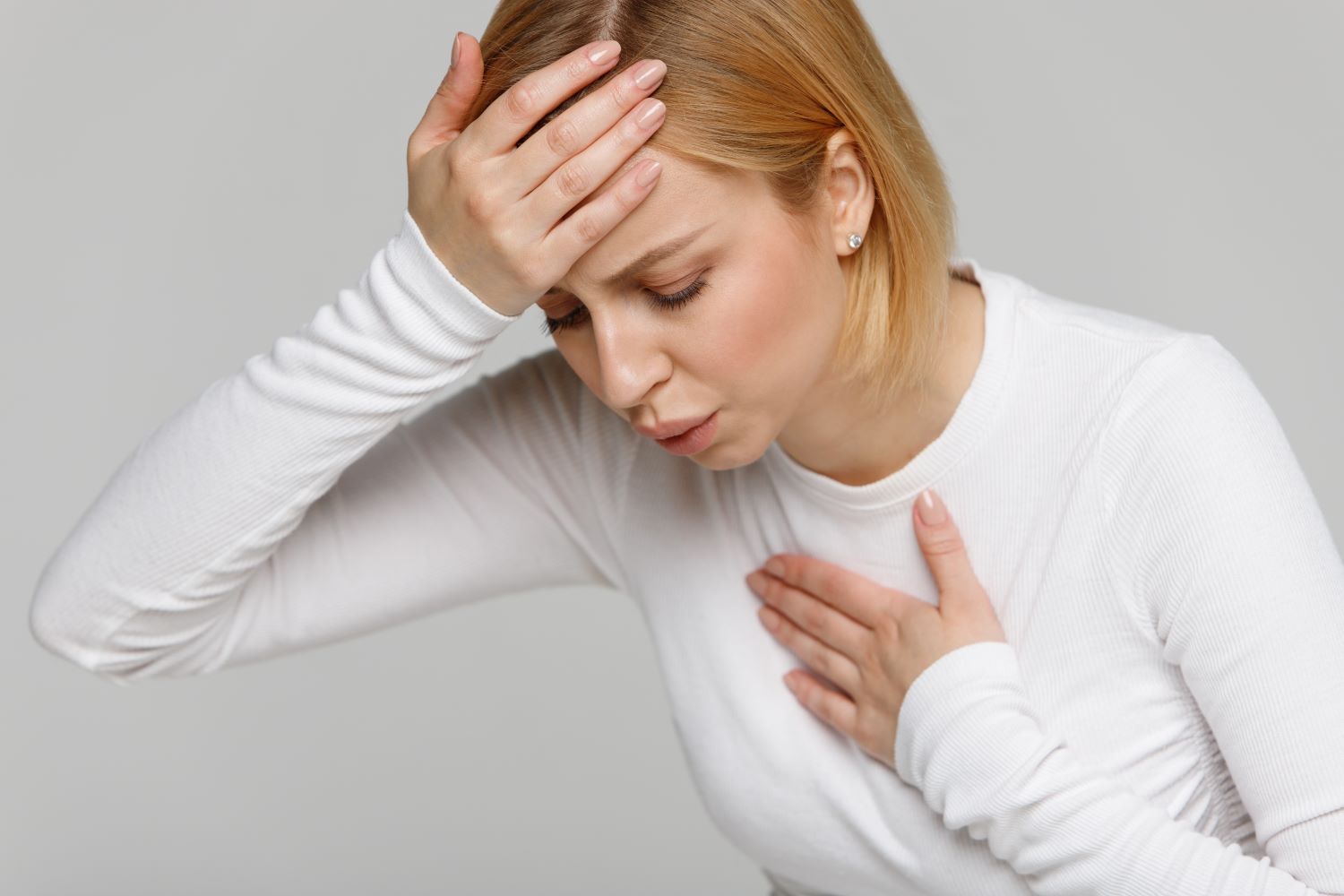 woman wearing a white shirt having an anxiety attack