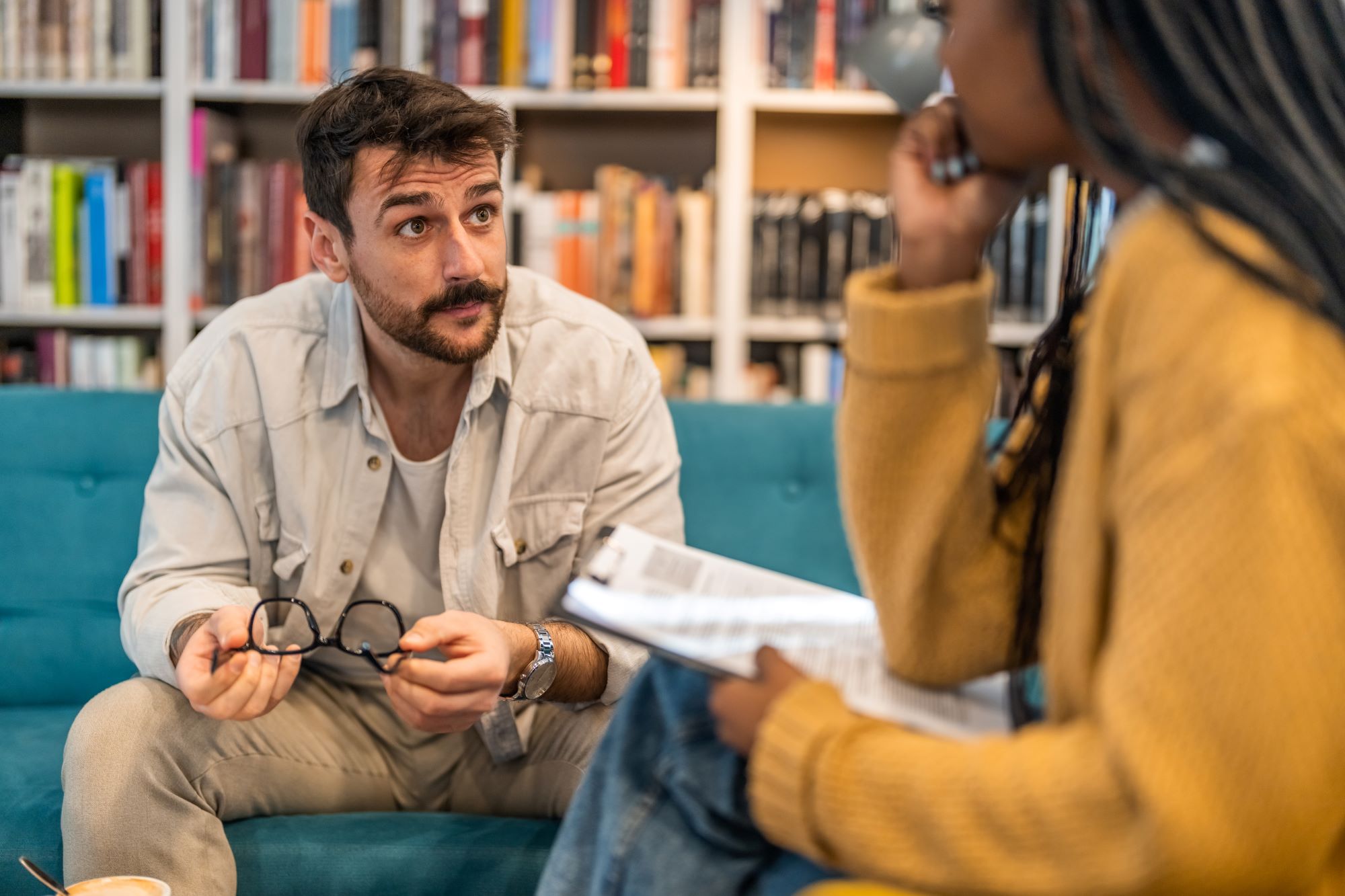 a white man being counseled by a black woman who is sitting across from him