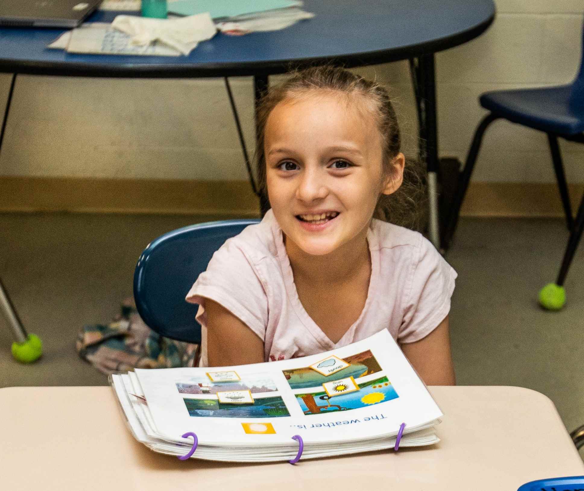 young girl with blond hair looking at a picture book