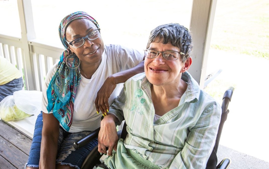 two smiling women sitting side by side