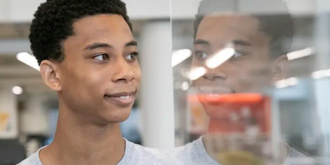 Teenage boy facing a window