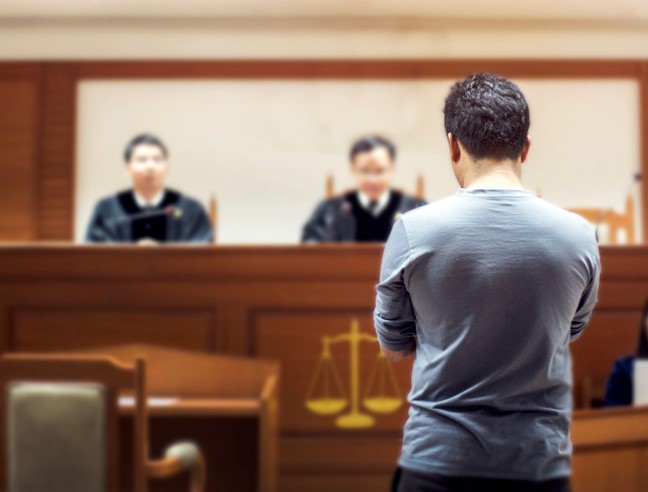 man in blue t-shirt standing in front of judges