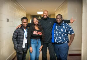 four smiling people looking at the camera