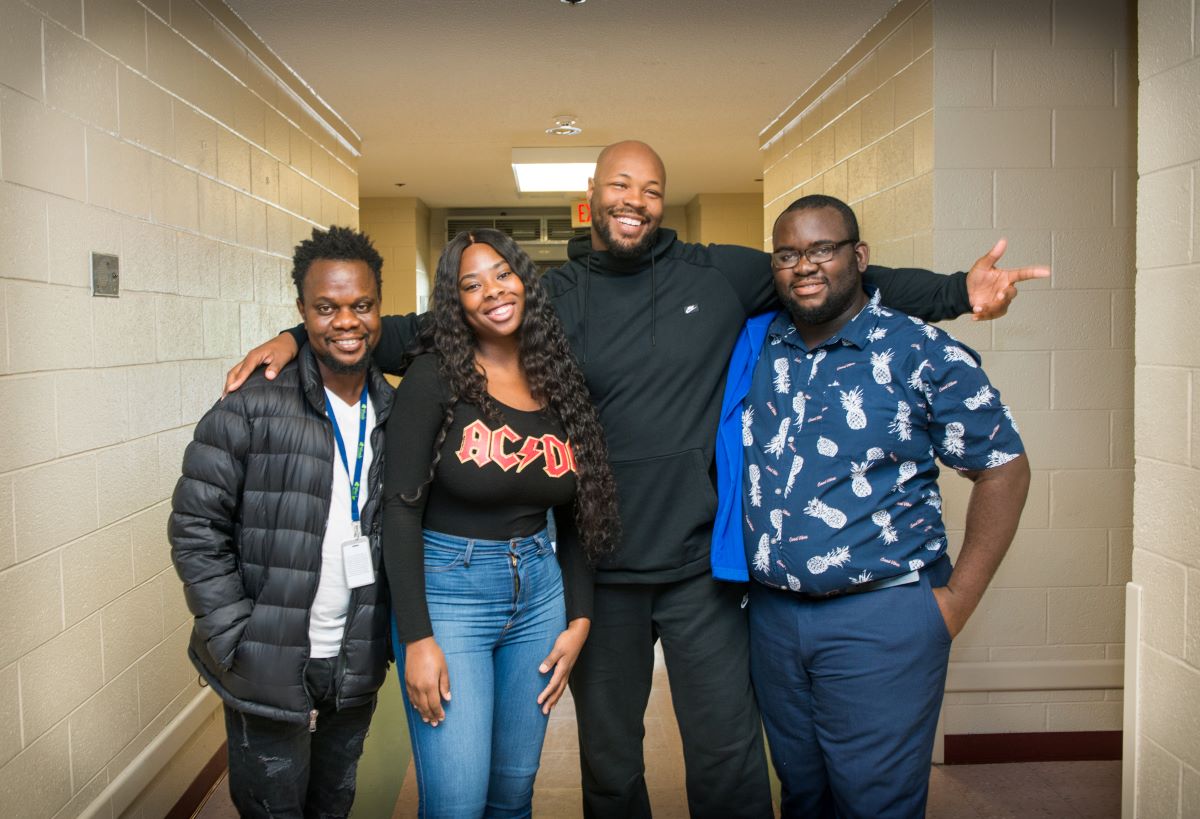 four smiling people looking at the camera