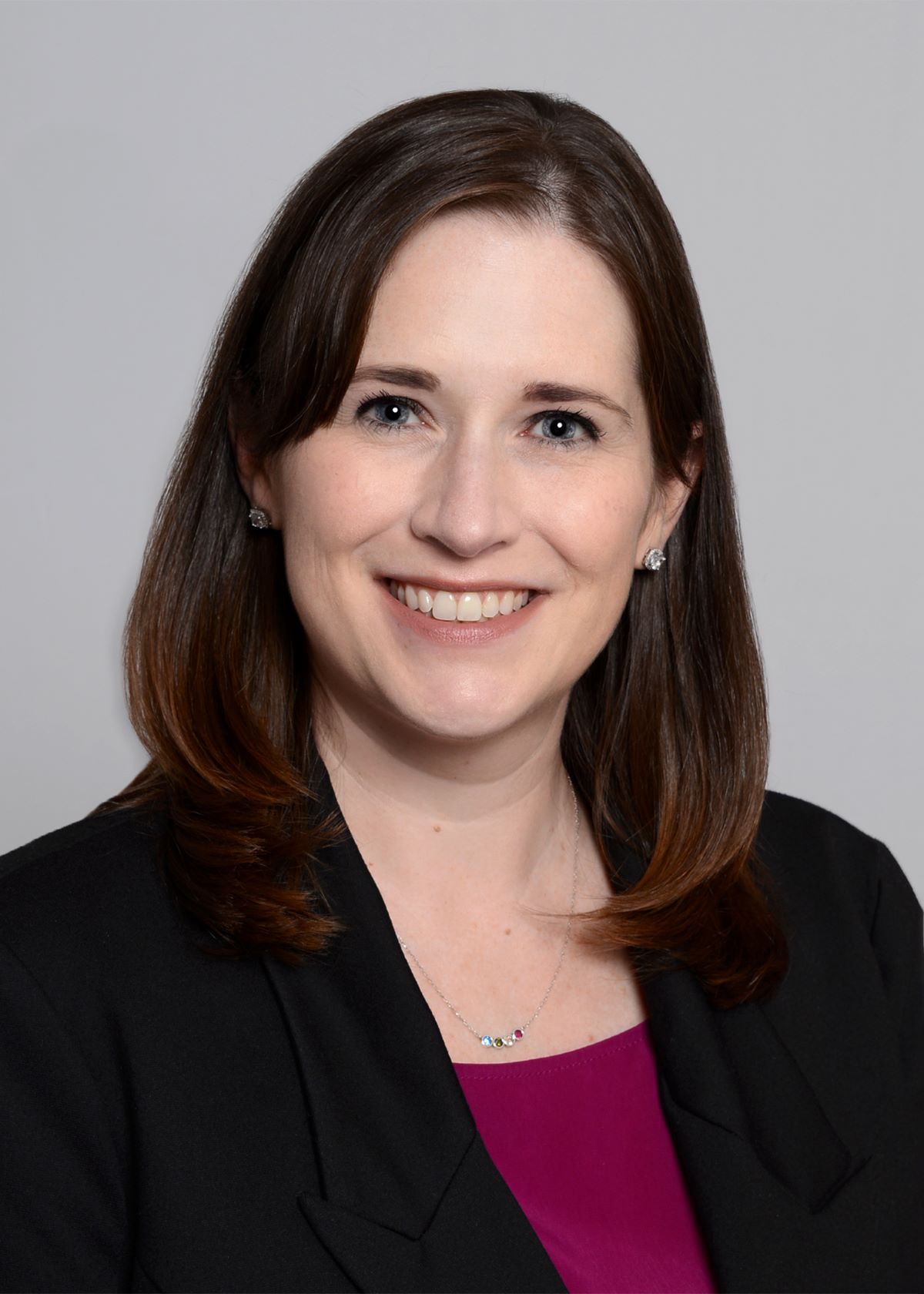 woman with dark shoulder length hair wearing a black blazer